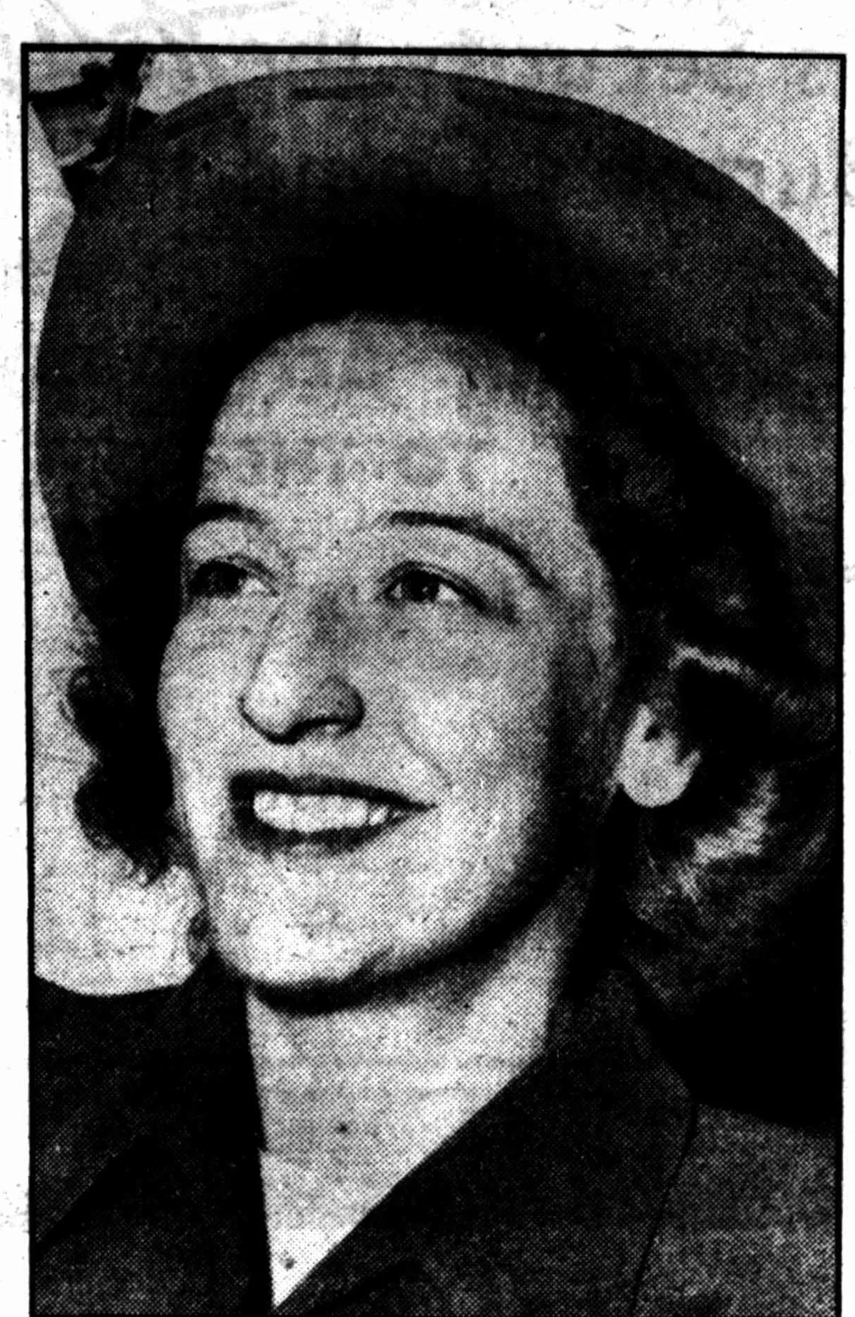 A newspaper portrait of a laughing woman in a dark felt hat.
